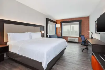 a hotel room with a large bed and a television at Holiday Inn Express & Suites Jersey City - Holland Tunnel by IHG in Jersey City