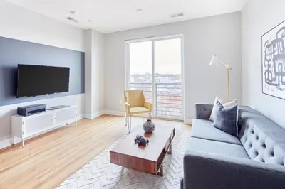 a living room with a couch and a tv at StayCozy at The Frankford in Philadelphia