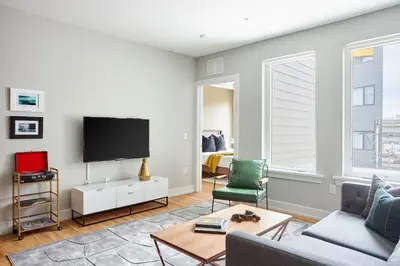 a living room with a couch and a tv at StayCozy at The Frankford in Philadelphia