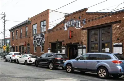 a row of parked cars parked on a city street at StayCozy at The Frankford in Philadelphia