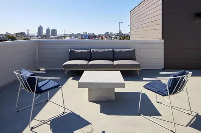 a couch on a rooftop with two chairs and a table at StayCozy at The Frankford in Philadelphia