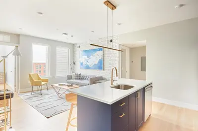 a kitchen and living room with a sink and a couch at StayCozy at The Frankford in Philadelphia
