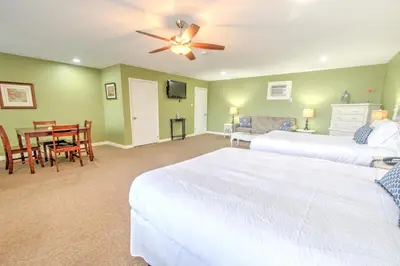 a bedroom with two beds and a dining room with a table at East Shore Lodging in Hawley