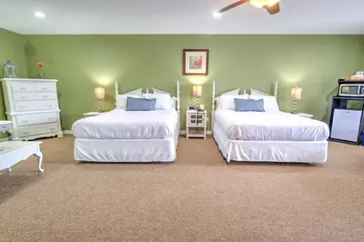 two beds in a bedroom with green walls at East Shore Lodging in Hawley