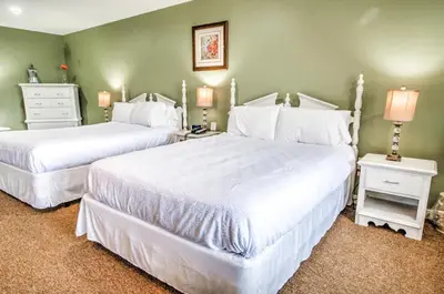 two beds in a bedroom with green walls at East Shore Lodging in Hawley