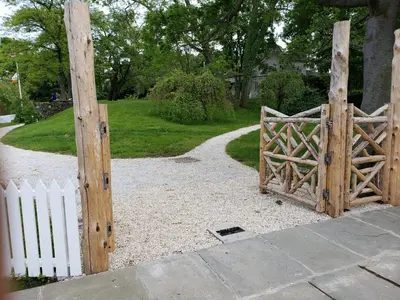 an open wooden gate with a white fence at Harbor House Bed and Breakfast in Staten Island