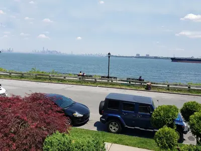 a blue truck parked on a road next to the water at Harbor House Bed and Breakfast in Staten Island