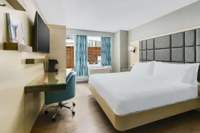 a hotel room with a bed and a desk at Hilton Garden Inn New York Times Square North in New York