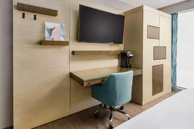a room with a desk and a tv on a wall at Hilton Garden Inn New York Times Square North in New York