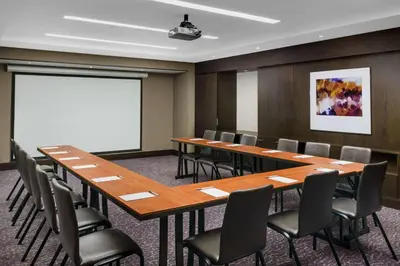 a conference room with tables and chairs and a whiteboard at Hilton Garden Inn New York Times Square North in New York