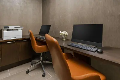 an office with a desk with a computer and two chairs at Hilton Garden Inn New York Times Square North in New York