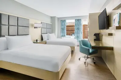 a hotel room with two beds and a desk at Hilton Garden Inn New York Times Square North in New York