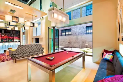 a billiards table in a room with a couch at Aloft Manhattan Downtown - Financial District in New York