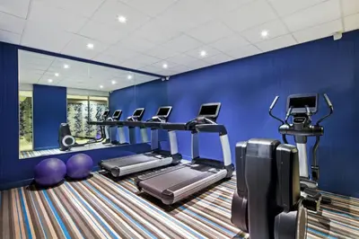 a gym with several tread machines in a blue wall at Aloft Manhattan Downtown - Financial District in New York