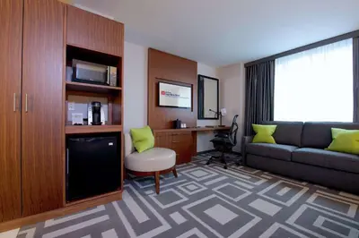 a hotel room with a couch and a desk at Hilton Garden Inn New York Central Park South-Midtown West in New York