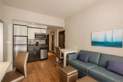 a living room with a couch and a kitchen at Homewood Suites Midtown Manhattan Times Square South in New York