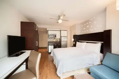 a bedroom with a bed and a desk and a tv at Homewood Suites Midtown Manhattan Times Square South in New York