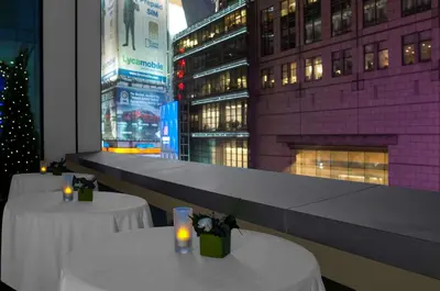 a restaurant with two tables with candles and a christmas tree at Hilton Garden Inn New York - Times Square Central in New York