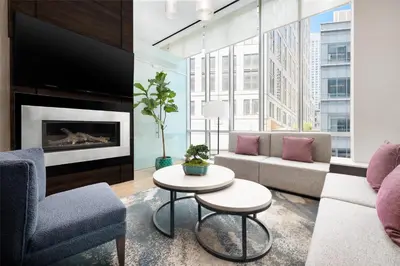 a living room with a couch and a fireplace at Hilton Garden Inn New York - Times Square Central in New York