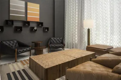 a living room with a couch and a table and chairs at Hilton Garden Inn New York/Midtown Park Avenue in New York