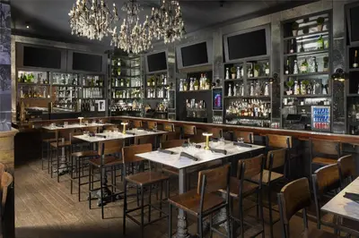 a restaurant with tables and shelves of alcohol at Hilton Garden Inn New York/Midtown Park Avenue in New York
