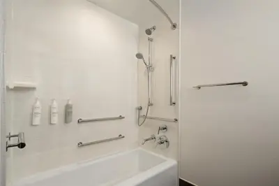a white bathroom with a tub and a sink at Hilton Garden Inn New York/Midtown Park Avenue in New York