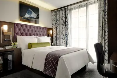 a hotel room with a bed and a window at Archer Hotel New York in New York