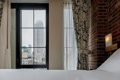 a bedroom with a bed and a window with a view at Archer Hotel New York in New York