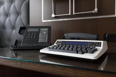a desk with a phone and a computer keyboard at Archer Hotel New York in New York