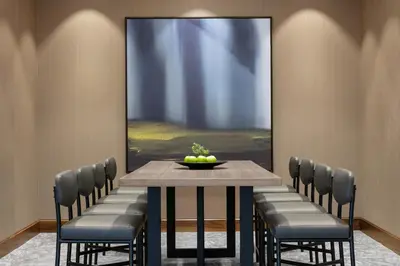 a dining room with a table with chairs and a painting at Hyatt Place Fort Lee/George Washington Bridge in Fort Lee