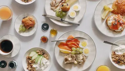 a white table with plates of food on it at WestHouse Hotel New York in New York