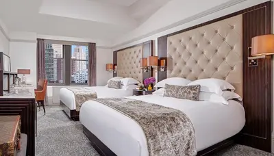 a hotel room with two beds and a desk at WestHouse Hotel New York in New York