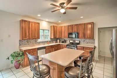 a kitchen with wooden cabinets and a ceiling fan at Blue Mtn Lake Family House, Steps to Beach! in East Stroudsburg