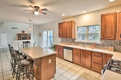 a kitchen with wooden cabinets and a ceiling fan at Blue Mtn Lake Family House, Steps to Beach! in East Stroudsburg