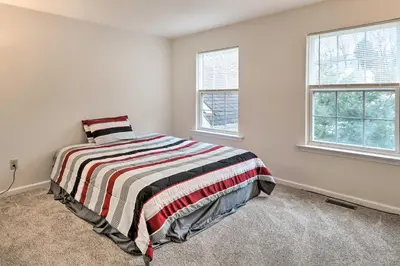 a bedroom with a bed and two windows at Blue Mtn Lake Family House, Steps to Beach! in East Stroudsburg