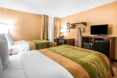 a hotel room with two beds and a flat screen tv at Quality Inn & Suites Towanda in Towanda