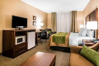 a hotel room with a bed and a flat screen tv at Quality Inn & Suites Towanda in Towanda