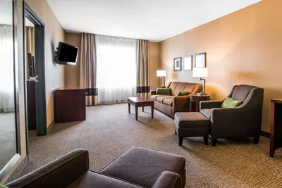 a hotel room with a couch and chairs and a tv at Quality Inn & Suites Towanda in Towanda