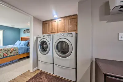 a laundry room with a washer and dryer next to a bed at Central Hummelstown Apt 4 Miles to Hershey Park! in Hummelstown