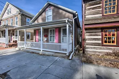 a home with a white porch and a wooden house at Central Hummelstown Apt 4 Miles to Hershey Park! in Hummelstown