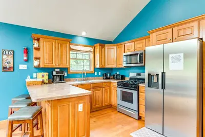 a kitchen with wooden cabinets and stainless steel appliances at Resort Amenities and Game Room Arrowhead Lake Home! in Pocono Lake