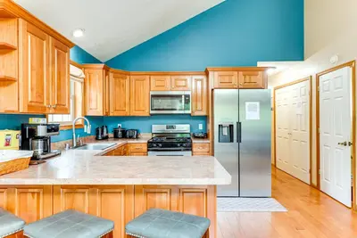 a kitchen with wooden cabinets and a refrigerator at Resort Amenities and Game Room Arrowhead Lake Home! in Pocono Lake