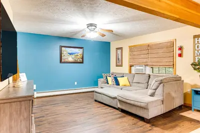 a living room with a couch and blue walls at Resort Amenities and Game Room Arrowhead Lake Home! in Pocono Lake