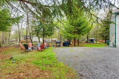 a group of chairs and a table in a yard at Resort Amenities and Game Room Arrowhead Lake Home! in Pocono Lake