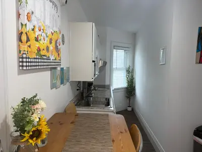 a dining room with a table and a kitchen at Cozy Private bedrooms Kitchen Wifi in Englewood