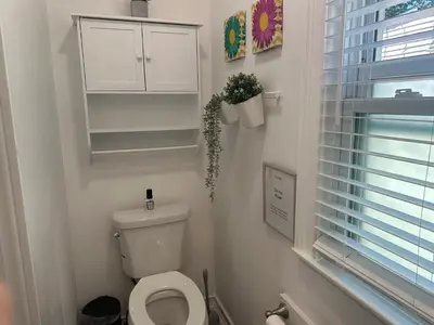 a white bathroom with a toilet and a window at Cozy Private bedrooms Kitchen Wifi in Englewood