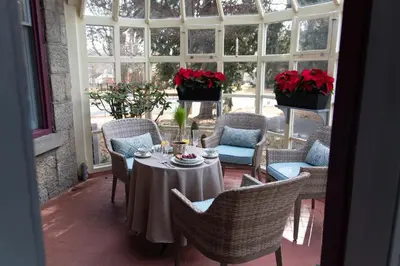 a patio with a table and chairs and flowers at Gifford-Risley House Bed and Breakfast in Media