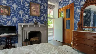 a bedroom with blue walls and a fireplace at Gifford-Risley House Bed and Breakfast in Media