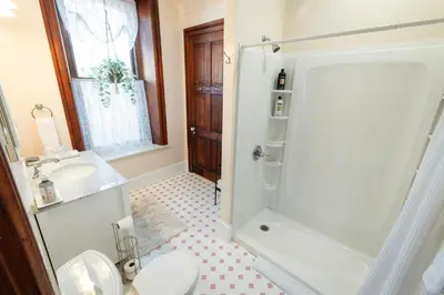 a bathroom with a shower and a toilet and a sink at Gifford-Risley House Bed and Breakfast in Media