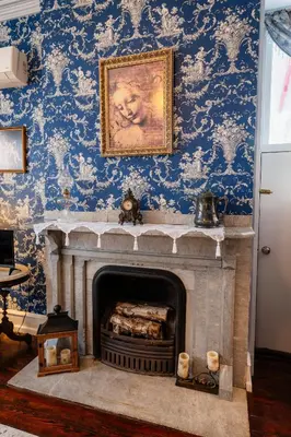 a fireplace in a room with blue wallpaper at Gifford-Risley House Bed and Breakfast in Media
